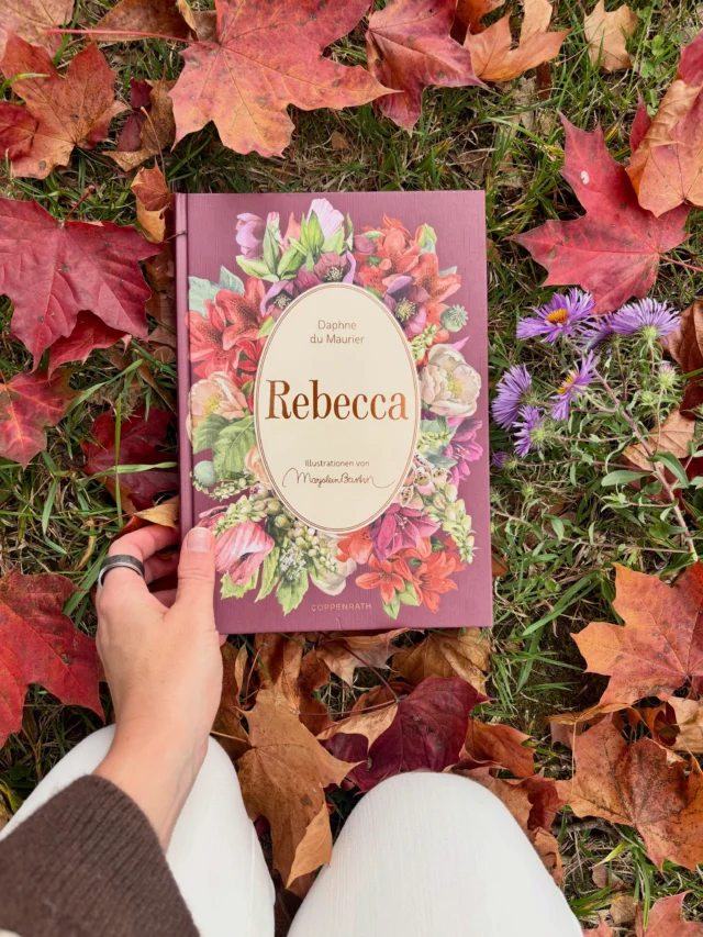 🍁 Mein Herbstbuch: „Rebecca“ von Daphne du Maurier

Oh mein Gott, ist dieses Buch schön! 

Als wir in meinem Buch-Club beschlossen haben, dass wir als Nächstes „Rebecca“ von Daphne du Maurier lesen, musste es für mich unbedingt diese Schmuckausgabe aus dem @coppenrathverlag sein - Ihr wisst ja, ich liebe diese Klassiker-Reihe und habe auch schon einige Ausgaben von Jane Austen und Arthur Conan Doyle im Regal stehen. Doch bei diesem Buch hat sich der Verlag selbst übertroffen: Das Cover mit Strukturpapier, Prägung und Goldfolie sowie die liebevolle Innengestaltung mit zahlreichen Einlegern passen einfach herrlich in die schaurig-schöne Herbstzeit. 🍂🕯️

„Rebecca“ beginnt in Monte Carlo: Eine junge Gesellschafterin lernt den verwitweten Maxim de Winter kennen, heiratet ihn überraschend und zieht mit ihm auf seinen Landsitz Manderley an der englischen Küste. Doch dort ist die verstorbene erste Ehefrau Rebecca allgegenwärtig. In den Räumen, den Erinnerungen der Angestellten und vor allem in der Verehrung durch die Haushälterin Mrs Danvers scheint sie noch immer präsent zu sein. Und je länger die neue Mrs de Winter in Manderley lebt, desto mehr dunkle Geheimnisse kommen ans Licht …

Daphne du Maurier veröffentlichte den Roman 1938 - und „Rebecca“ gilt heute als Klassiker der Gothic Novel und psychologischen Spannungsliteratur. Der Roman wurde mehrfach verfilmt, am bekanntesten ist vermutlich Alfred Hitchcocks Adaption von 1940. 2020 folgte eine modernere Netflix-Verfilmung. Ich habe tatsächlich noch keine der beiden gesehen, denn als Erstes möchte ich das Buch lesen. 

Wie ist es bei Euch: Kennt Ihr „Rebecca“ schon - als 📖 oder 🎥?